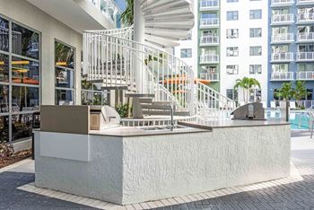 A white staircase with a metal railing is in front of a building.